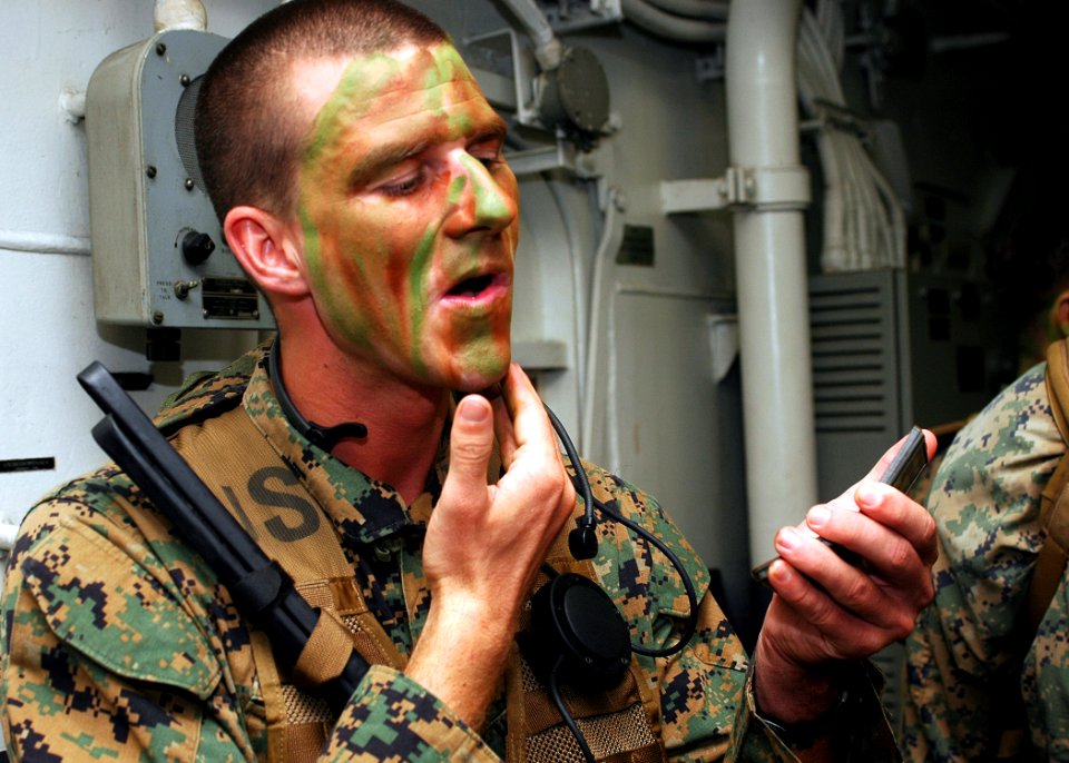 US Navy 080725-N-5681S-004 Cpl. Brandon Liesenfelt, assigned to the 26th Marine Expeditionary Unit (26 MEU), applies camouflage in the hangar bay of the multi-purpose amphibious assault ship USS Iwo Jima (LHD 7)