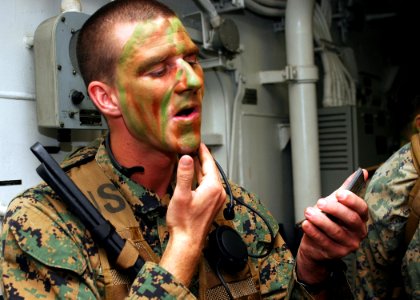 US Navy 080725-N-5681S-004 Cpl. Brandon Liesenfelt, assigned to the 26th Marine Expeditionary Unit (26 MEU), applies camouflage in the hangar bay of the multi-purpose amphibious assault ship USS Iwo Jima (LHD 7)