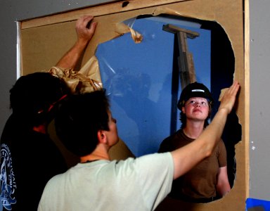 US Navy 080731-N-3674H-014 Constructionman Krista Beech, assigned to Naval Mobile Construction Battalion (NMCB) 74, helps install a window at the USO at Camp Virginia, Kuwait