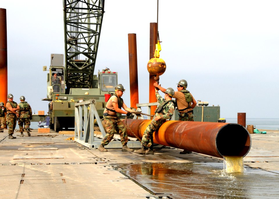 US Navy 080731-N-1424C-336 Seabees assigned to Amphibious Construction Battalion (ACB) 1 and Amphibious Construction Battalion (ACB) 2 unhook crane cables from the pile