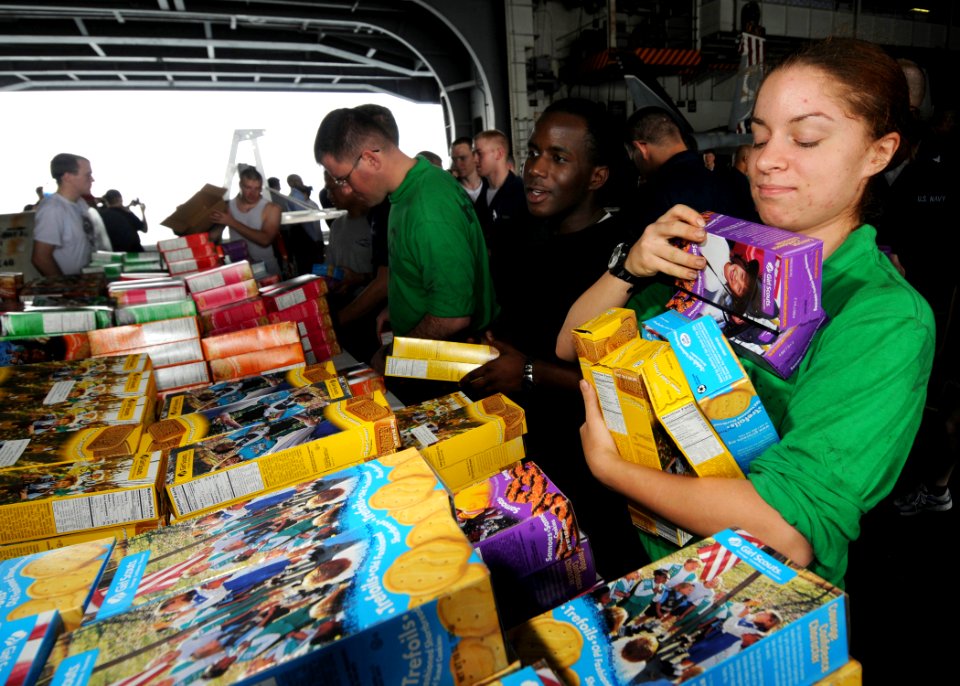 US Navy 080726-N-9898L-009 Aviation Machinist's Mate Airman Ashley Schumm picks up boxes of cookies from Girl Scouts participating in Operation Cookie Drop