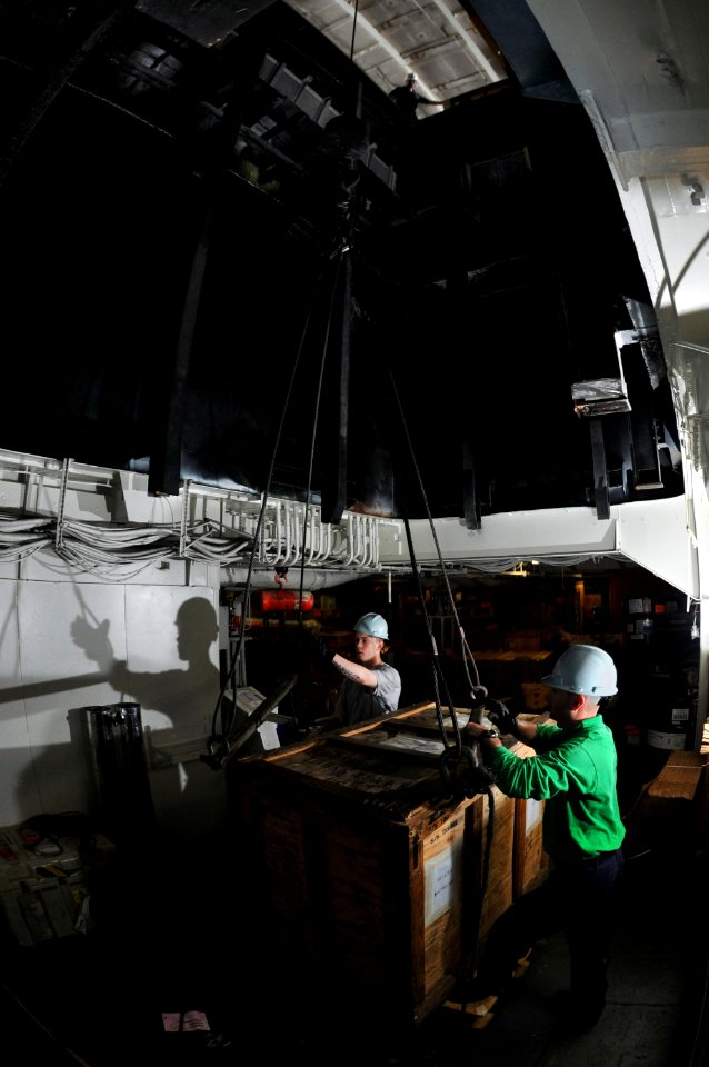 US Navy 080807-N-7981E-201 Storekeeper Seaman Edwin Bracey, right, and Storekeeper Seaman Jason Serio rig a crate to be craned out of an aviation storeroom into the hangar bay aboard the aircraft carrier USS Abraham Lincoln (CV