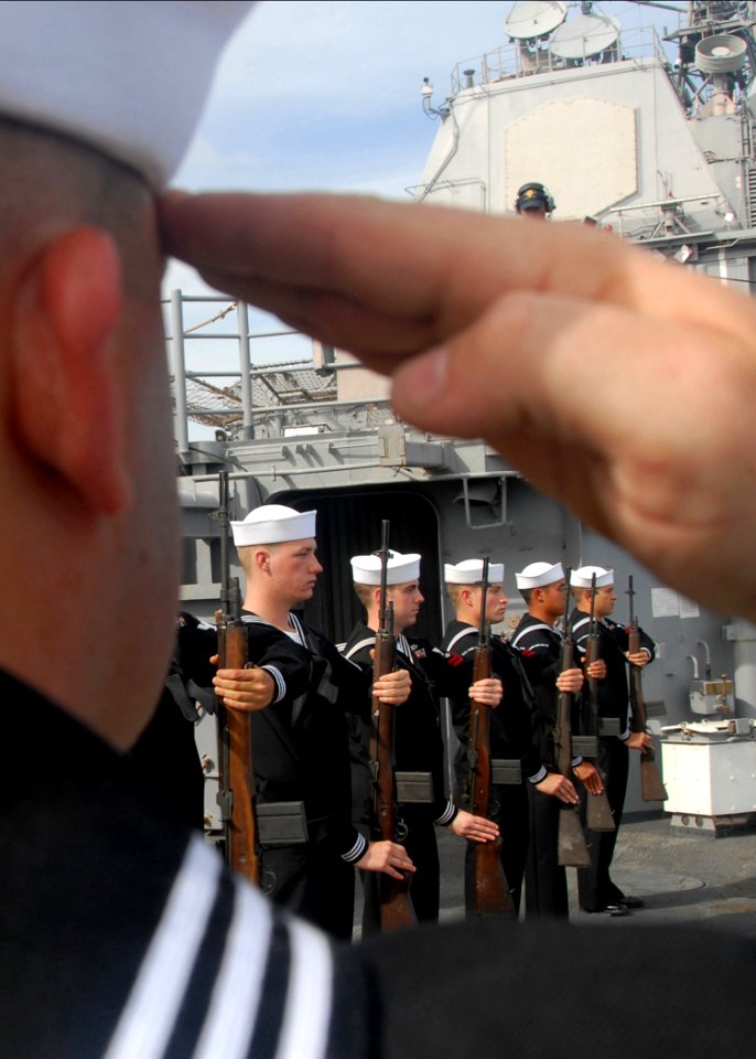 US Navy 080805-N-9758L-276 An honor guard detail performs a rifle salute during a burial at sea ceremony