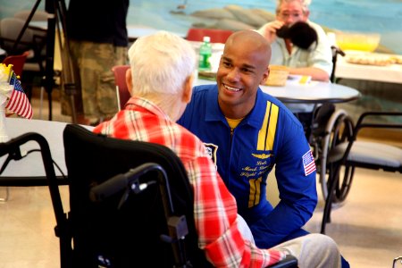 US Navy 080808-N-3271W-037 Lt. Cmdr. Mark Lambert, flight surgeon for the Navy flight demonstration squadron Blue Angels, visits with a resident of the nursing home care center at Spokane Veterans Administration Hospital photo
