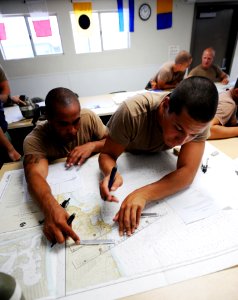 US Navy 080729-N-6552M-090 Basic crewman training (BCT) students lay out navigational tracks on a chart photo