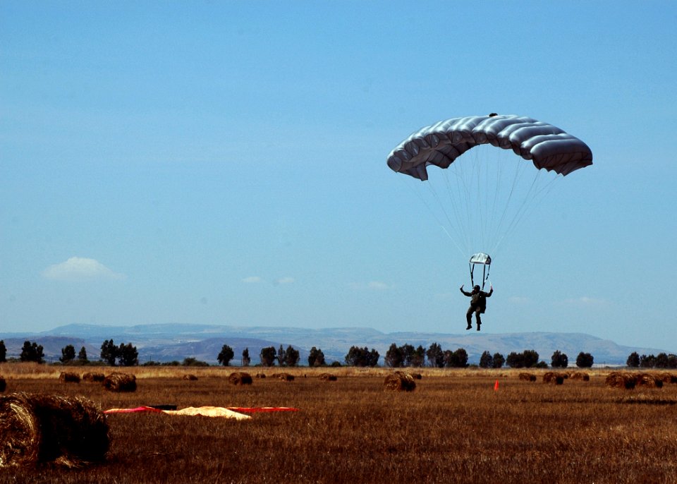 US Navy 080730-N-0577G-101 Aircrew Survival Equipmentman 1st Class Gregory Kufchak, assigned to Explosive Ordnance Mobile Unit Eight (EODMU) 8, lands during a free-fall parachute jump over Naval Air Station Sigonella