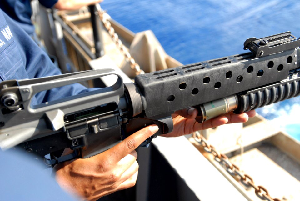 US Navy 080806-N-7730P-202 Aviation Electronic's Technician 3rd Class Awail Hassen loads a high explosive point detonated 40MM grenade round into an M203 grenade launcher