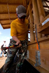 US Navy 080809-N-6674H-007 Chief Intelligence Specialist (Sel.) John Reeder, assigned to Joint Intelligence Operations Command, hammers supports for a deck to be built on a new house for a Habitat for Humanity community service photo