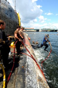 US Navy 080810-N-8933S-082 Navy Diver 1st Class Michael Linzy jumps off the former Soviet submarine-urned museum, Juliett 484. The submarine sank at her mooring point in about 30 feet of water after a nor'easter struck Providen