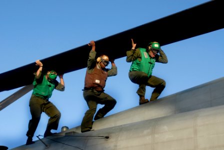 US Navy 080808-N-3595W-047 Marines from Marine Heavy Helicopter Squadron (HMH) 464 roll the blades of a CH-53E Super Stallion aboard the amphibious assault ship USS Kearsarge (LHD 3)
