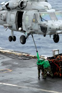 US Navy 080808-N-7730P-070 Chief Store Keeper Ronald Cruz and Midshipman Danielle Chlopek attach a sling to an HH-60H Seahawk assigned to the