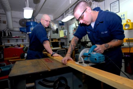 US Navy 080809-N-1635S-002 Hull Maintenance Technician Fireman Tyler Peterson, from Oakland, Neb., cuts wood to build a table aboard the Nimitz-class aircraft carrier USS Ronald Reagan (CVN 76)