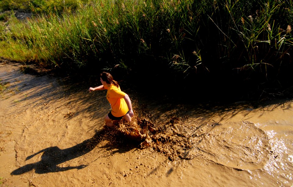 US Navy 080809-N-5345W-372 A runner sloshes her way through the final mud pit as she approaches the finish line of the eighth annual Health Net Armed Services YMCA Mud Run at Naval Amphibious Base Little Creek