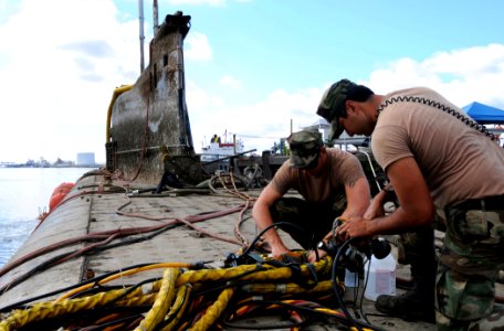 US Navy 080809-N-8933S-162 Navy Diver 1st Class James Ohalek and Boatswain's Mate 1st Class William Bailey clean dive helmets after a dive under the former Soviet submarine-turned museum, Juliett 484, in Providence photo