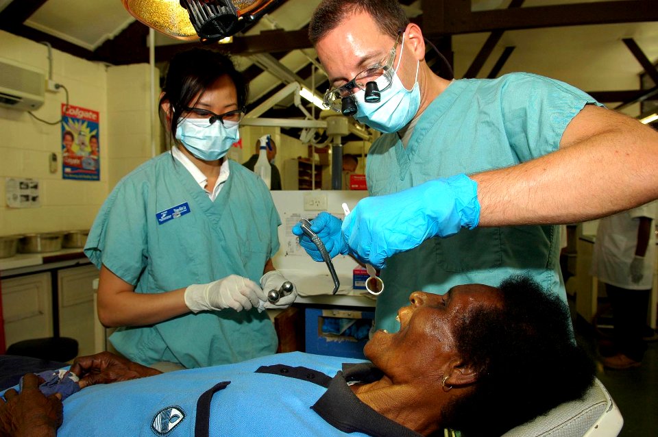 US Navy 080807-N-5086M-010 Thien-Kim Le, a University of California at San Diego (UCSD) student representing the UCSD Pre-Dental Society, assists Capt. Alex Smith, a U.S. Army dentist from New York, during a tooth extraction