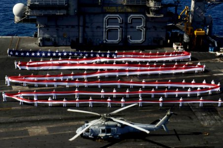 US Navy 080807-N-7883G-103 Sailors aboard the aircraft carrier USS Kitty Hawk (CV 63) display a homecoming pennant on the flight deck as the ship heads for San Diego