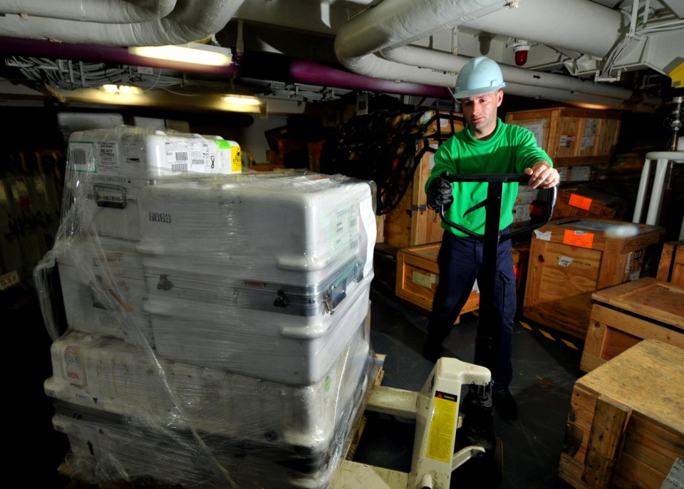 US Navy 080807-N-7981E-186 Storekeeper Seaman Edwin Bracey, of Columbus, Miss., positions a pallet of parts in an aviation storeroom aboard the aircraft carrier USS Abraham Lincoln (CVN 72)