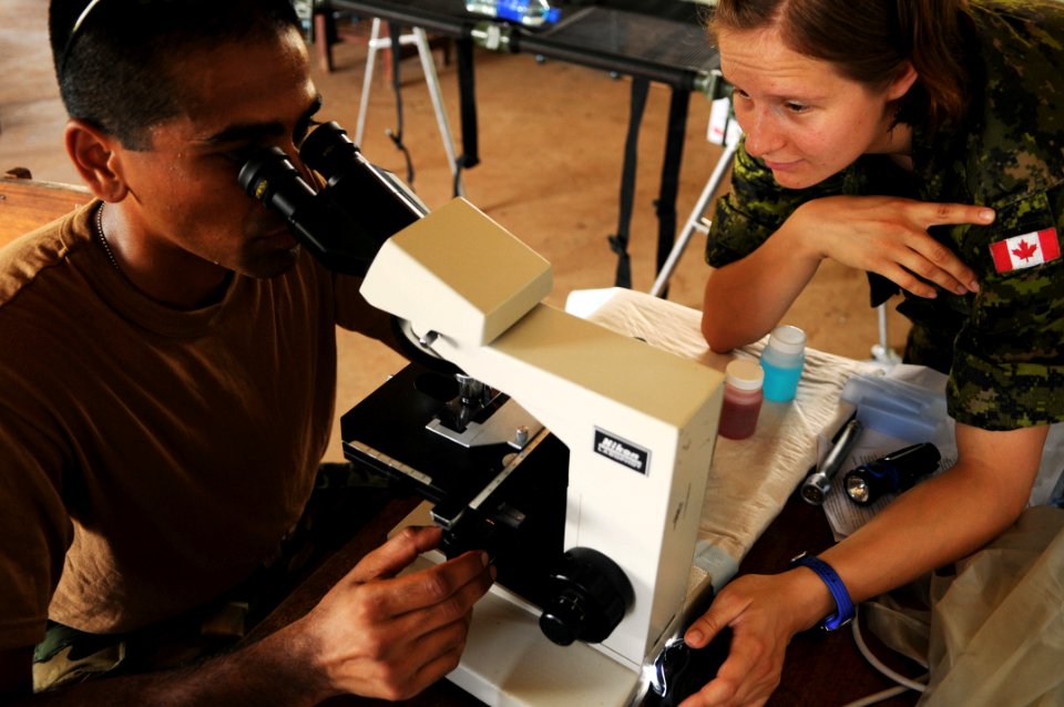 US Navy 080814-N-4515N-049 Cmdr. Sugat Patel, officer-in-charge of the medical and dental site at Juan Comenius High School, and Canadian Army Lt. Luaren Vera, both embarked aboard the amphibious assault ship USS Kearsarge (LHD