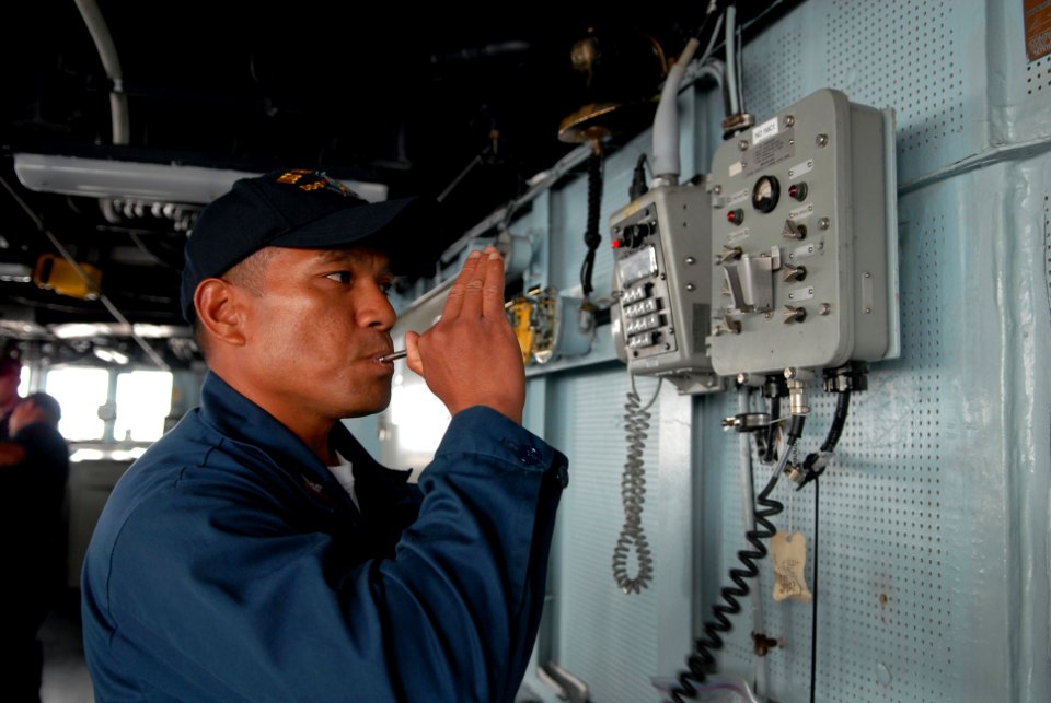 US Navy 080813-N-1635S-001 Boatswain's Mate 2nd Class Samson Kattil, from Hawaii, pipes the ship's whistle from the pilothouse of the Arleigh Burke-class guided-missile destroyer USS Howard (DDG 83)