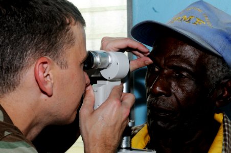 US Navy 080812-N-9774H-121 Lt. Johnny Cosby, a Navy augmentee working as an optometrist aboard the amphibious assault ship USS Kearsarge (LHD 3), conducts an eye exam on a patient