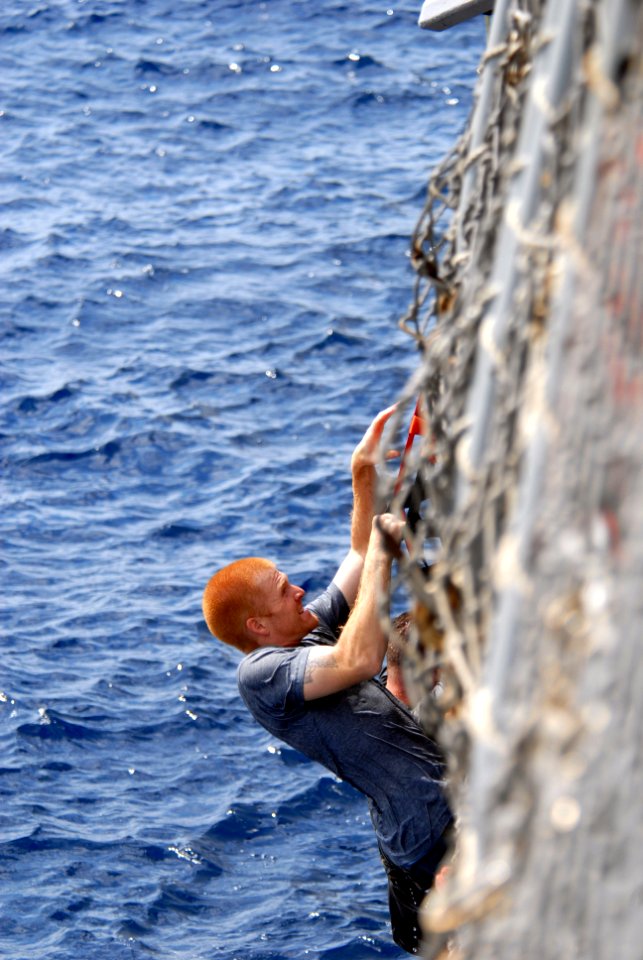 US Navy 080815-N-1635S-004 Electronics Technician 3rd Class Colby Karaim, from Montana, climbs back up to the flight deck of the Arleigh Burke-class guided-missile destroyer USS Howard (DDG 83) during a scheduled swim call