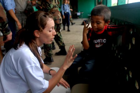 US Navy 080813-N-3595W-108 Project Hope volunteer Sara Joyce finds out how old a child is while the boy waits in line to be check by a medical volunteer from the amphibious assault ship USS Kearsarge (LHD 3) photo