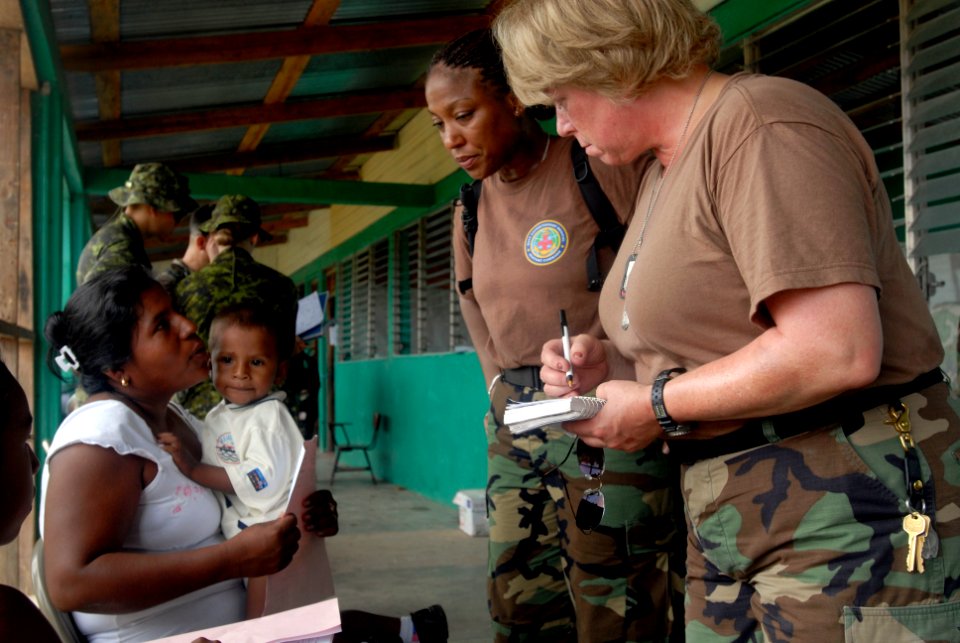US Navy 080813-N-3595W-158 Cmdr. Andrea Parodi and Hospital Corpsman 1st Class Adelina Luna, both assigned to the amphibious assault ship USS Kearsarge (LHD 3), register patients before they are seen by doctors