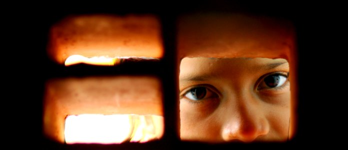 US Navy 080813-N-4515N-421 A young girl peers through bricks in the auditorium of Juan Comenius High School during a Continuing Promise 2008 humanitarian assistance project in Puerto Cabezas