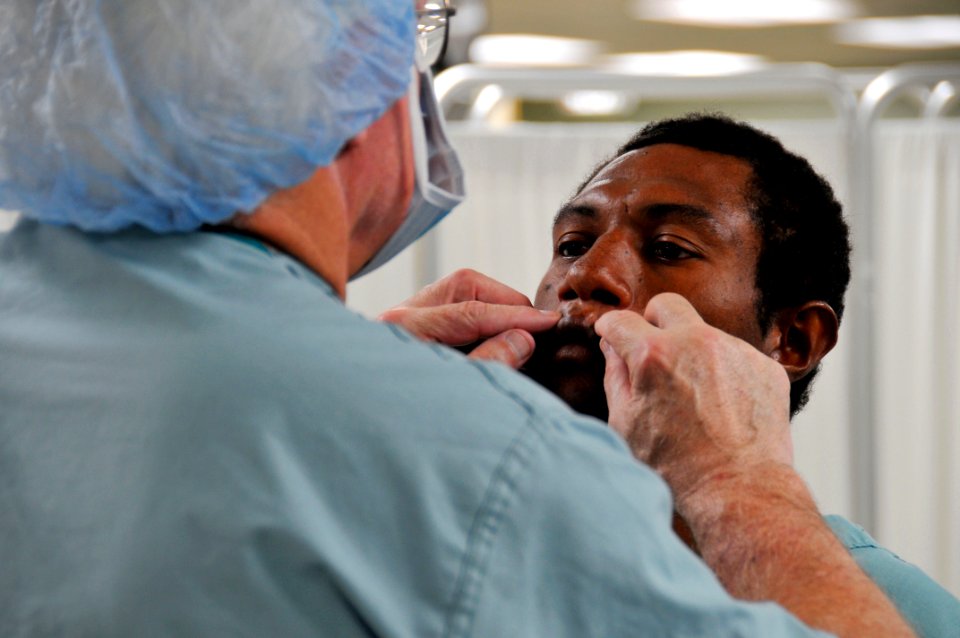 US Navy 080811-N-9689V-005 Operation Smile volunteer Dr. Robert Russell, a plastic surgeon from Springfield, Ill., examines a patient before performing reconstructive surgery