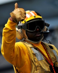 US Navy 080814-N-7981E-128 Aviation Boatswain's Mate (Handling) 1st Class Corey Cooper gives a thumbs up while directing aircraft on the flight deck of the Nimitz-class aircraft carrier USS Abraham Lincoln (CVN 72) photo