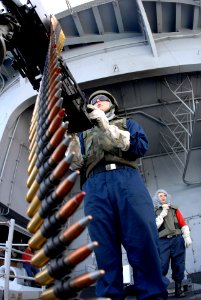 US Navy 080816-N-7730P-042 Gunner's Mate Seaman Brian Utne takes aim on a .50-caliber machine gun at a floating target (Killer Tomato) during a training exercise aboard the Nimitz class aircraft carrier USS Ronald Reagan (CVN 7