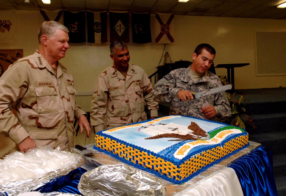 US Navy 080816-N-8273J-320 Culinary Specialist 3rd Class Adam Leduc cuts a cake in honor of Chief of Naval Operations (CNO) Adm. Gary Roughead, left, and Master Chief Petty Officer of the Navy (MCPON) Joe R. Campa Jr