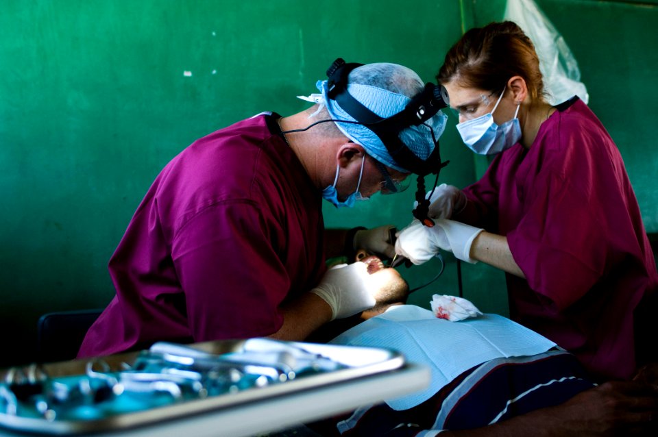 US Navy 080814-N-9620B-018 Cmdr. Michael Hill, a dentist embarked aboard amphibious assault ship USS Kearsarge (LHD 3), works on the teeth of a Nicaraguan woman at the dental clinic at Llano Verde School