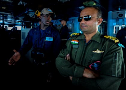US Navy Ensign Muctarr Bah speaks with Indian Navy Capt. Anil Komao in the bridge during a replenishment-at-sea exercise