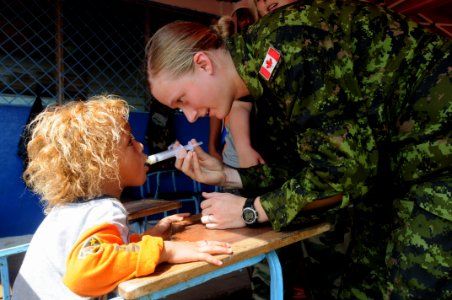 US Navy 080817-N-7955L-035 Canadian Air Force Pvt. Tabitha Beynen, embarked aboard the amphibious assault ship USS Kearsarge (LHD 3), uses a syringe to give de-worming medication into a child
