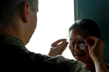 US Navy 080813-N-7544A-086 Lt. Jonny L. Cosby checks the vision of a Nicaraguan woman to prescribe glasses during a humanitarian assistance project in Puerto Cabezasn Nicaragua during the Caribbean phase of Continuing Promise 2 photo