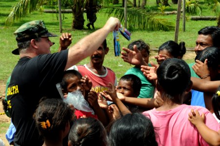 US Navy 080817-N-7955L-164 U.S. Public Health Service Lt. Cmdr. Gary Brunette, embarked aboard the amphibious assault ship USS Kearsarge (LHD 3), hands out toothbrushes to children in Betania