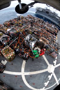 US Navy 080815-N-5961C-008 Two Sailors aboard the Military Sealift Command fast combat support ship USNS Bridge (T-AOE 10) hook cargo pendants to an SH-60 Sea Hawk helicopter