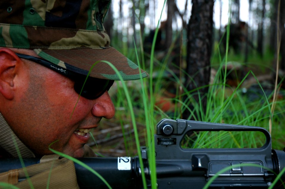 US Navy 080818-N-7367K-001 Equipment Operator 1st Class Edwin Ortiz, assigned to Naval Mobile Construction Battalion (NMCB) 1, sights in on a simulated enemy force as his squad moves forward during the squad leaders course at C