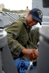 US Navy 080814-N-0641S-007 Seaman Afelisha Wiltshire paints equipment on the weather deck of the guided-missile cruiser USS Port Royal (CG-73)