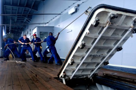 US Navy 080815-N-8546L-014 Sailors assigned to the engineering repair division aboard the amphibious command ship USS Blue Ridge (LCC 19) raise an external hatch to perform maintenance on the watertight gasket and moving parts