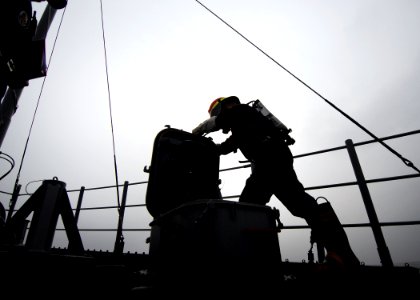 US Navy 080819-N-0807W-152 A Sailor wearing a self-contained breathing apparatus opens a scuttle