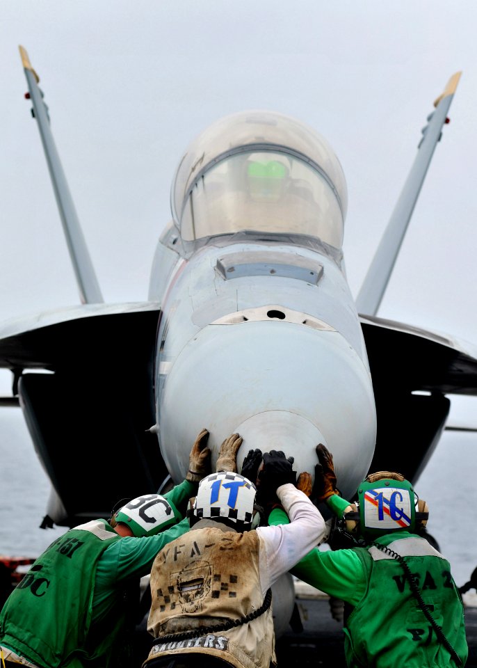 US Navy 080814-N-7981E-347 Flight deck personnel push an F-A-18F Super Hornet into place on the flight deck of USS Abraham Lincoln (CVN 72)