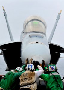US Navy 080814-N-7981E-347 Flight deck personnel push an F-A-18F Super Hornet into place on the flight deck of USS Abraham Lincoln (CVN 72)