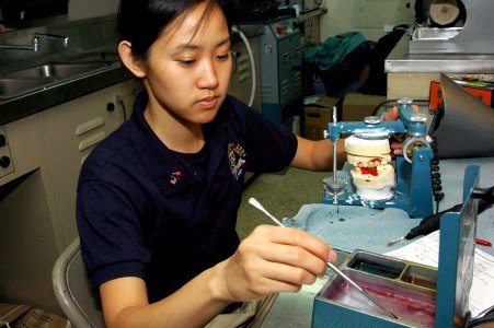 US Navy 080816-N-5086M-025 University of California at San Diego (UCSD) student, Thien-Kim Le, uses wax for tooth placement on a set of dentures
