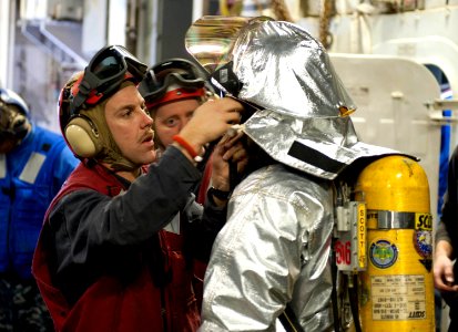 US Navy 120125-N-VY256-147 A Sailor dons his firefighting gear during flight quarters