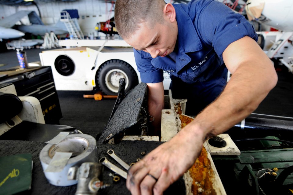US Navy 120130-N-RG587-162 A Sailor bolts the console cover onto a jet tow tractor