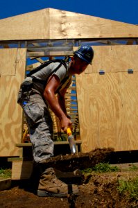 US Navy 080818-N-1508S-155 Airman 1st Class Jonathan Oliver, embarked aboard the amphibious assault ship USS Kearsarge (LHD 3), lays the foundation to a walkway leading to training centers under construction at the Regional Gov