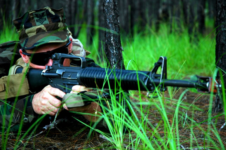 US Navy 080818-N-7367K-003 Construction Mechanic 1st Class David McGowen, assigned to Naval Mobile Construction Battalion (NMCB) 1, maintains his position on the firing line as his troops advance toward a simulated enemy force