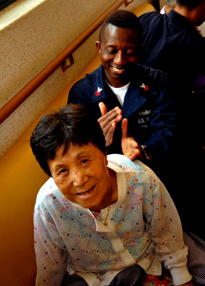 US Navy 080821-N-7280V-171 Storekeeper 1st Class Yayah Sesay gives a massage to an elderly woman at the Bluebird Home for the Aged during a community relations project
